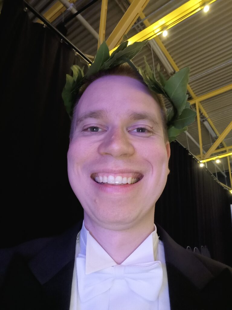 Kuva kirjoittajasta hymyilemässä laakeriseppele päässään